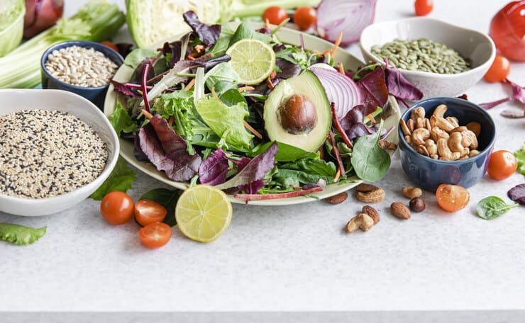 A vibrant bowl of salad filled with fresh vegetables, nuts, and various ingredients, perfect for a vegan diet. Ideal for managing eczema.