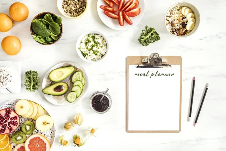 A colorful meal plan featuring healthy vegan foods on a white background, designed for managing eczema effectively.