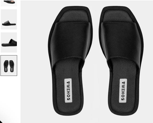 A pair of black vegan flat slides made from Desserto® cactus leather, featuring a sleek black strap design.